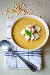 Pea soup in a white plate with crackers. lunch. Pieces of bread lie on a wooden board