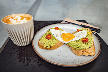 Classical breakfast close up toasts with avocado and sunny side egg