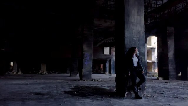 Drone round shot of a girl standing and smoking inside of abandoned Jerma Palace Hotel in Malta