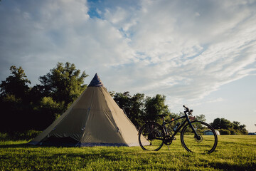 Fahrräder an einem Tipi-Zelt auf einem Campingplatz im Licht der Abendsonne