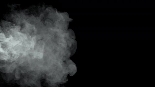 Billowing smoke covers the frame on a black background. Turbulent smoke or fog gently drifting and covering the entire frame.