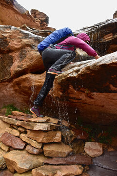 Woman climbing up a waterfall in Canyonlands National Park.
