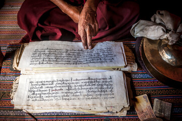A monk with buddhist scriptures in Hemis monastery, Ladakh, India.