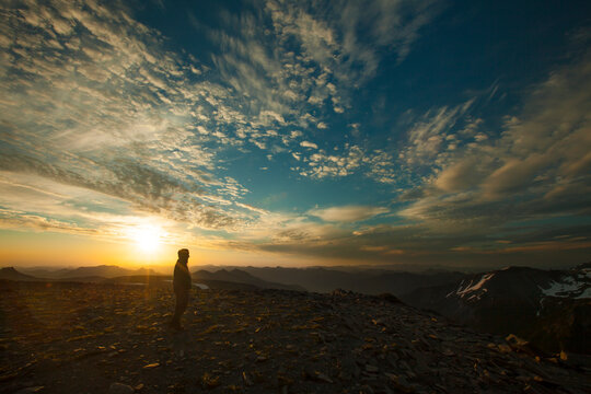 A hiker enjoys the sunrise from Burroughs Mountain in Mount Ranier National Park.