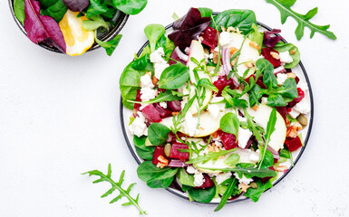 Beet, feta cheese and pear healthy salad with arugula, lamb lettuce, red onion, chard and walnut,...
