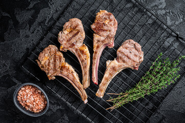 Barbecue Grilled lamb meat chops, mutton cutlets. Black background. Top view