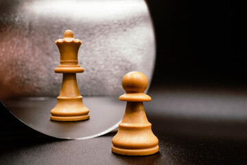 Career advancement, skill improvement, growth. White queen chess piece in the reflection of the pawn in the mirror. Pawn promotion to queen. Creative photo