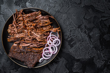 BBQ pulled pork meat on plate. Black background. Top view. Copy space