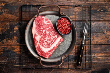 Foto op Canvas Raw wagyu rib eye beef meat steak in steel tray. Wooden background. Top view © Vladimir