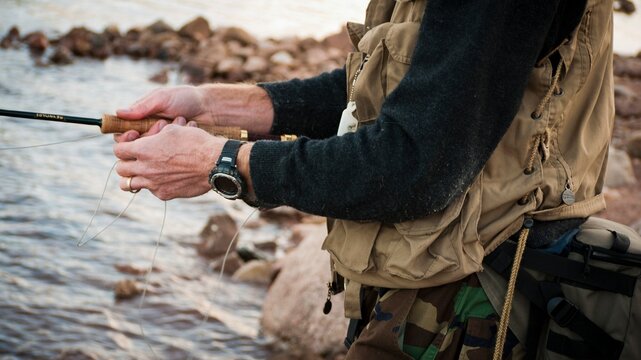 A young man in his early thirties  fly fishing near Durango, Colorado.