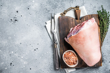 Uncooked Raw pork ham hocks, shanks on a wooden board with spices. Gray background. Top view. Copy...