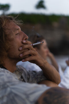 Man smoking a cigarette by the ocean