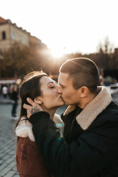 Man and woman kisses under the autumn sun in the center of Prague