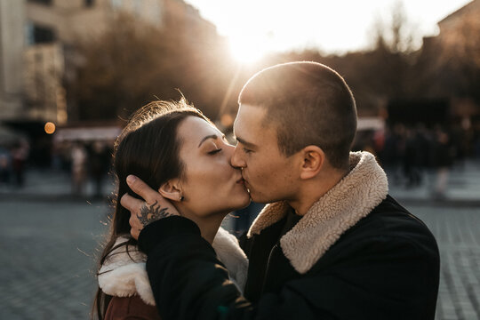Man and woman kisses under the autumn sun in the center of Prague