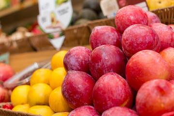 A box of fruit with a yellow and red fruit in the background