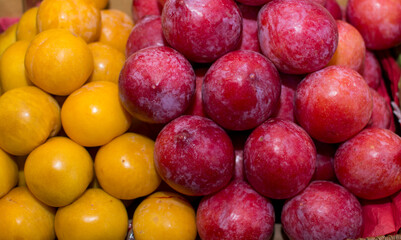 A box of fruit with a yellow and red fruit in the background