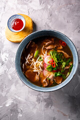 Soup Pho Bo in bowl on gray stone table