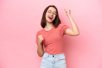 Young Ukrainian woman isolated on pink background celebrating a victory