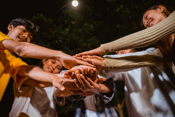 a group of people doing a high fived together while camping at the camp site