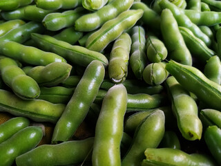 Fresh raw broad beans in the market, close-up, horizontal photo