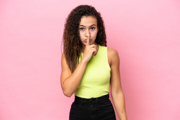 Young hispanic woman isolated on pink background showing a sign of silence gesture putting finger in mouth