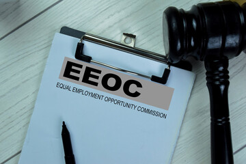 Concept of EEOC - Equal Empoyment Opportunity Commission write on paperwork isolated on Wooden...