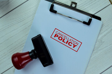 Concept of Red Handle Rubber Stamper and Cancellation Policy text isolated on on Wooden Table.