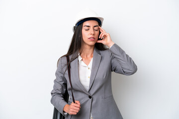 Young architect caucasian woman with helmet and holding blueprints isolated on white background with headache