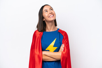 Super Hero caucasian woman isolated on white background looking up while smiling