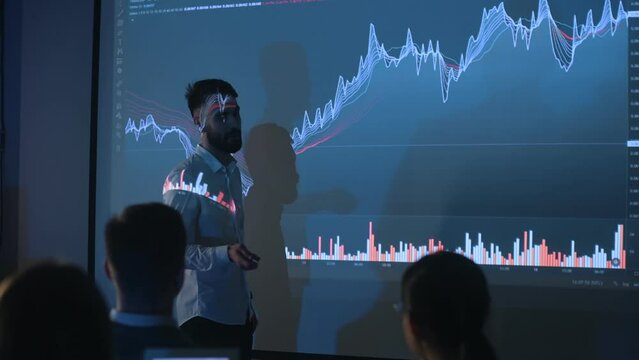 Future of company. Man in formal clothes is showing business plan on the big projector for the people.