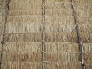 An intimate view of the traditional thatched roofs in a rural village. The thatched roofs can be sun-protected from the rain. And good ventilation. Old hay or dry grass background

