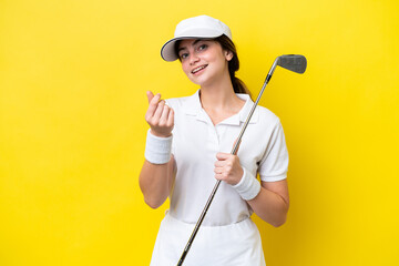 young caucasian woman playing golf isolated on yellow background making money gesture