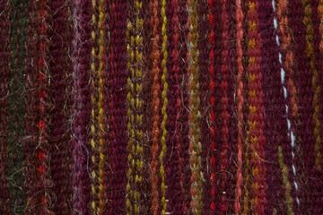 Textile woolen background. Knitted fabric with multi-colored threads. Soft hairy surface.