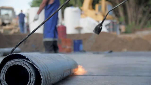 Connecting layers of hydrophobic covering protection with flame burner at constriction site closeup. Ground preparation
