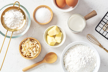 Baking background with cake or bakery ingredients, butter, flour, sugar and eggs ingredients on marble kitchen table