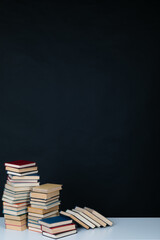 many books large stacks on the table in the library on a black background
