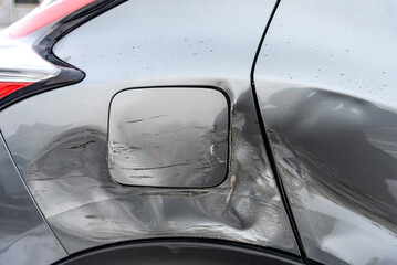 Silver car after the accident, broken door, fender and fuel tank close-up. Car accident close-up. A...