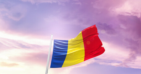 Waving Flag of Romania in Blue Sky. The symbol of the state on wavy cotton fabric.