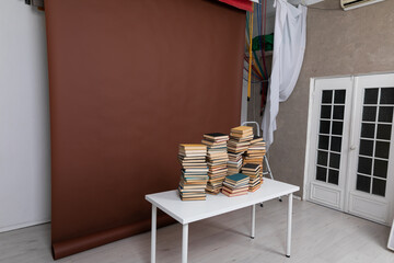 lots of books on the table in the room with a brown background