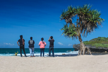 Tourists are vacationing on the beach in summer. People playing in the water on the beach during the day.