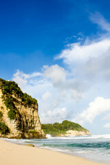 Fototapeta premium Tropical paradise beach with white sand and cliffs and blue sky with clouds on Sunny day. Summer tropical landscape, panoramic view. travel tourism wide panorama background concept. 