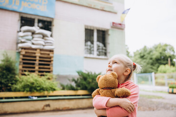 07.07.22 Irpin, Ukraine: a little Ukrainian girl holds a toy tightly in her hands. Russia's...