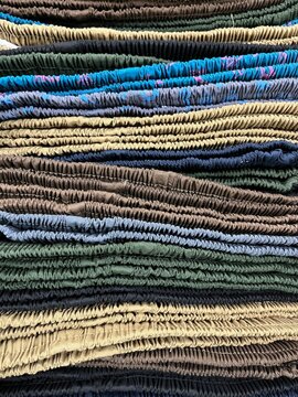 Vertical image stack of colorful shorts pants with elastic waist being displayed in a store.