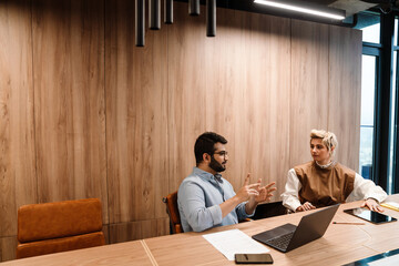 Two coworkers discussing business plan during brainstorming business meeting