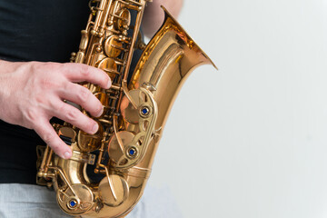 Hand of man playing on saxophone. Musician plays sax. Picture with copy space