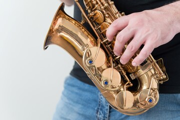 Hand of man playing on saxophone. Musician plays sax