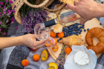 wine, fruits, berries, cheese, glasses picnic in lavender field. Selective focus
