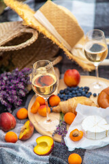 wine, fruits, berries, cheese, glasses picnic in lavender field. Selective focus