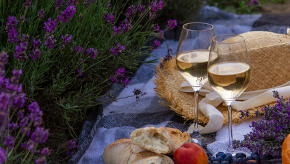 wine, fruits, berries, cheese, glasses picnic in lavender field. Selective focus