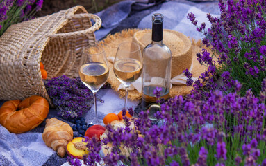 Obraz na płótnie Canvas wine, fruits, berries, cheese, glasses picnic in lavender field. Selective focus